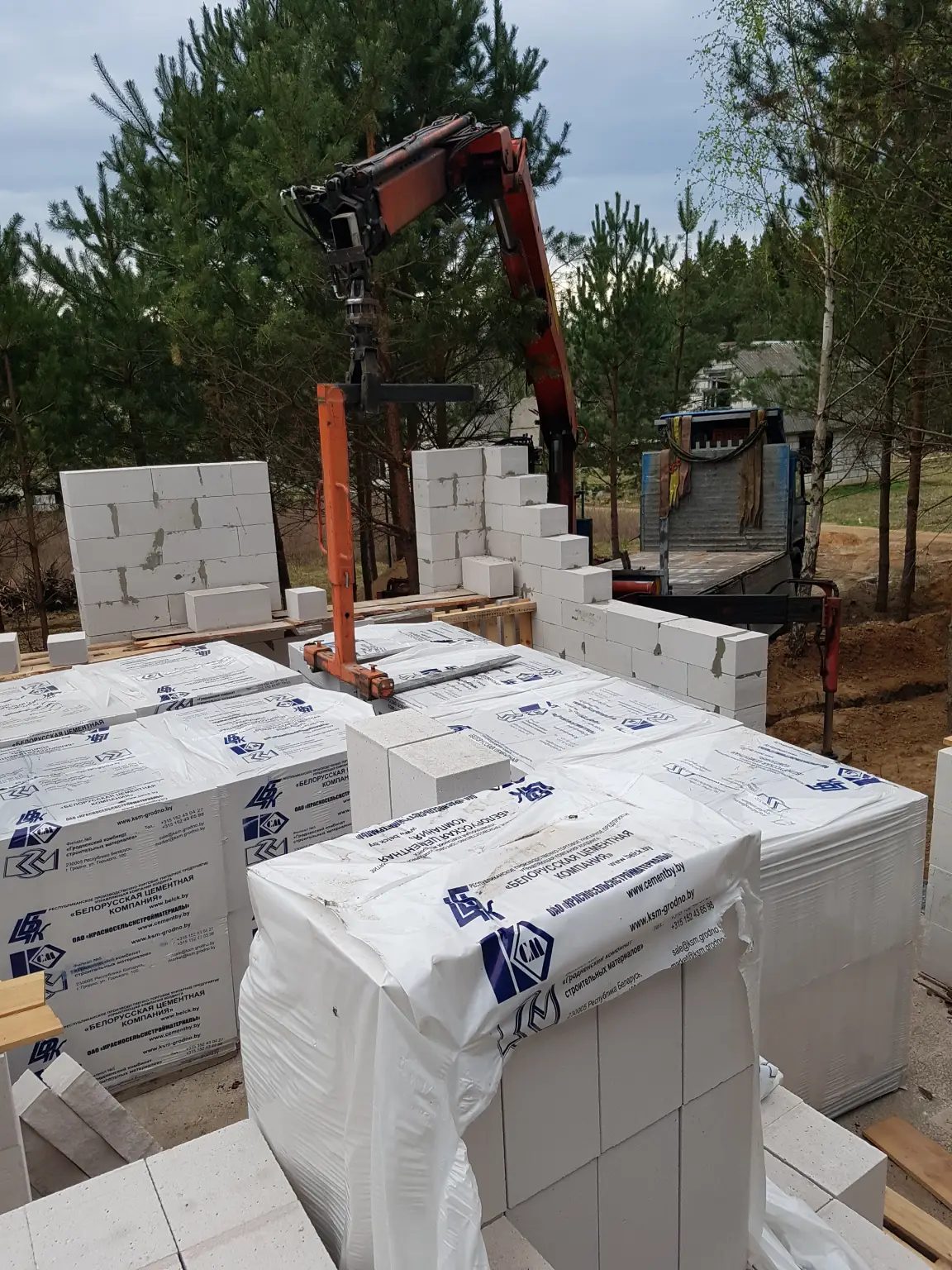 Подача газосиликатных блоков манипулятором на фундамент дома в Гродно