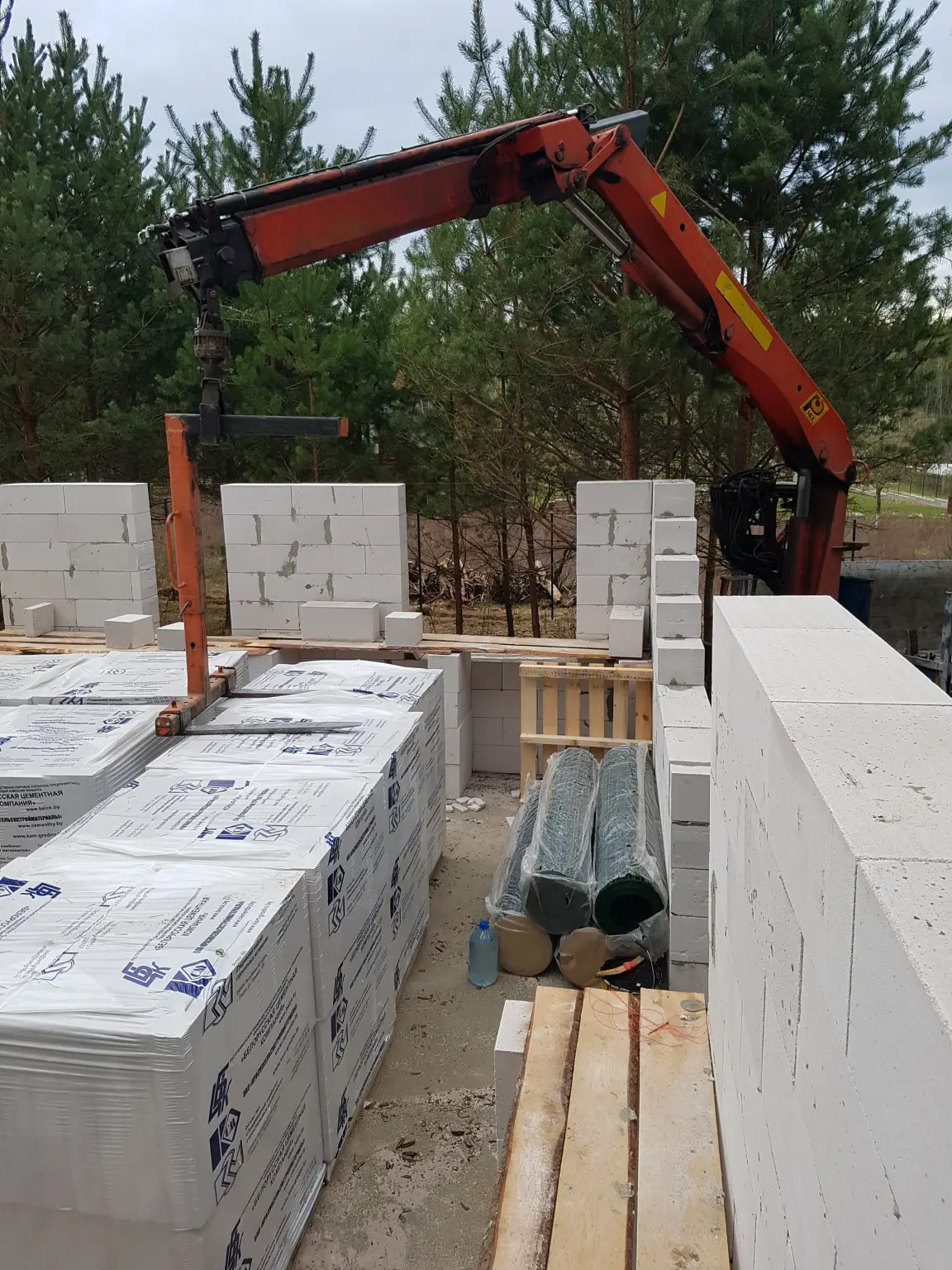 Подача газосиликатных блоков манипулятором внутрь строящегося дома в Гродно