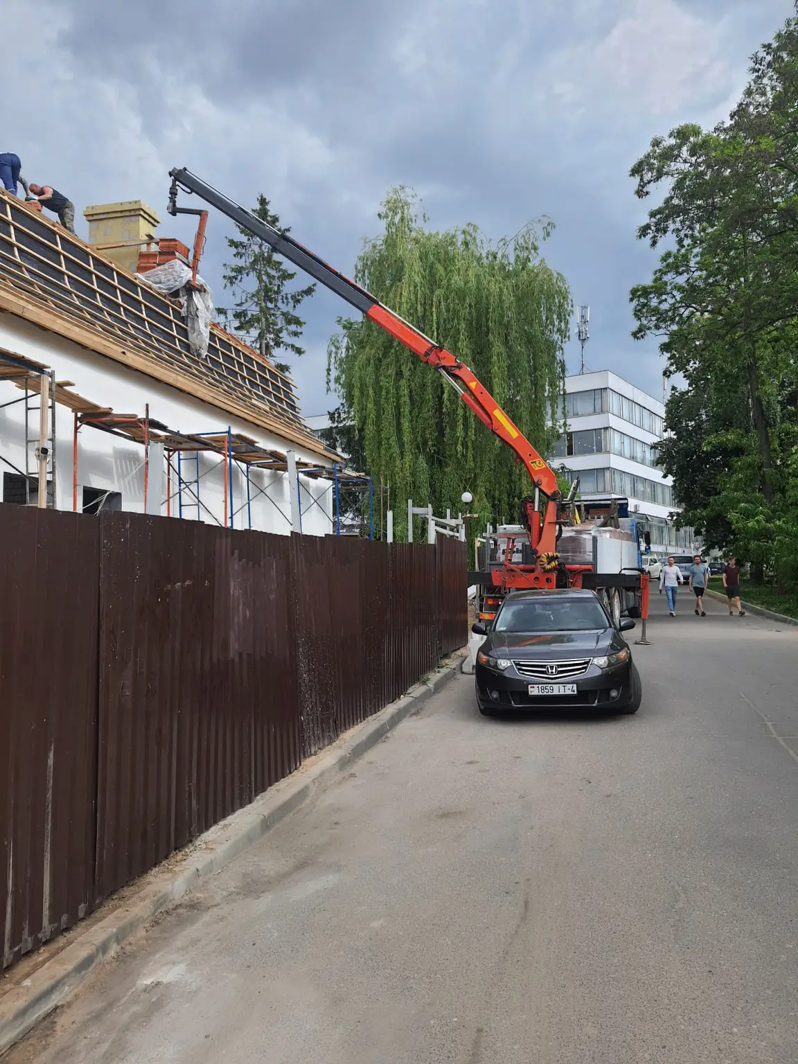 Подача строительных материалов манипулятором на крышу здания в Гродно